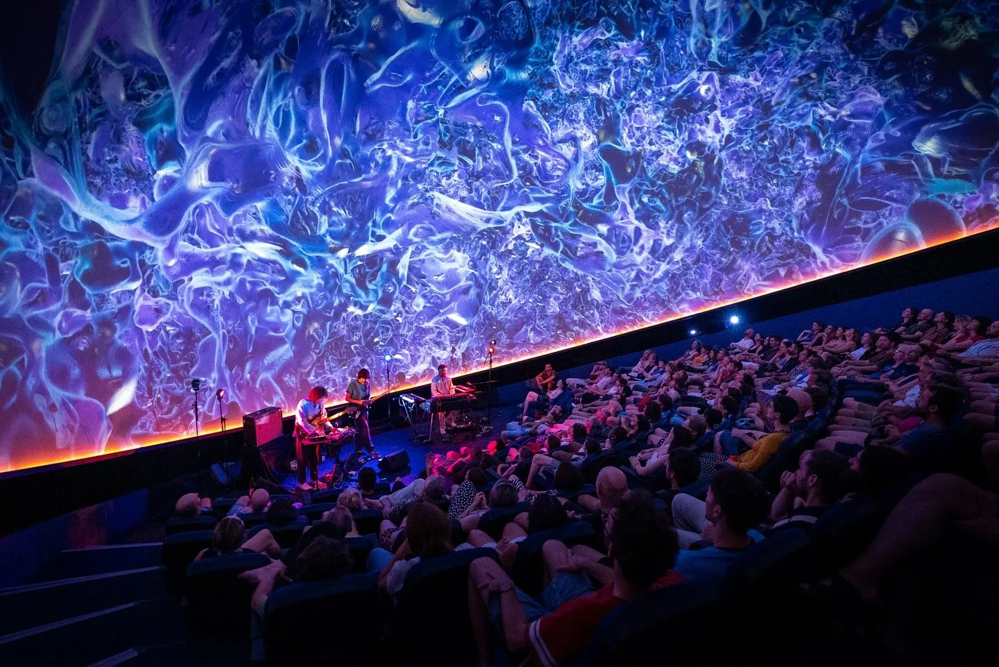 Green forms above the audience